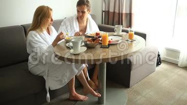 年轻夫妇在<strong>酒店</strong>房间的沙发上吃<strong>早餐</strong>
