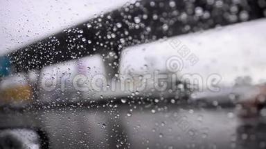 关上车窗玻璃上的雨滴和模糊的交通环境，阴雨昏暗的背景