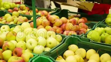 超市里的一个工人把水果<strong>苹果</strong>放进托盘里