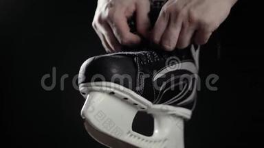 <strong>冰球运动</strong>员，溜冰鞋带，黑色背景。 近距离手准备比赛加拿大冰