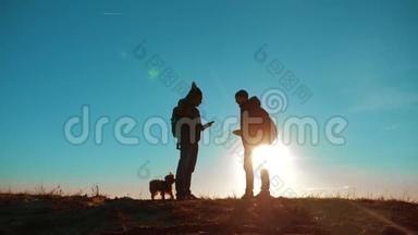 团队合作。 两名游客徒步<strong>旅行</strong>，男人和狗带着背包在日落时<strong>去</strong>徒步<strong>旅行</strong>。 慢动作视频。 智能手机