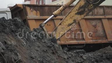 慢动挖掘机斗在建筑工地挖土并在卡车后面倾倒