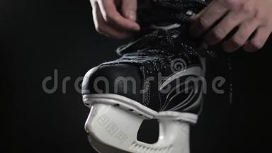 <strong>冰球运动</strong>员，溜冰鞋带，黑色背景。 近距离手准备比赛加拿大冰