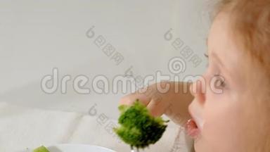 在家里的餐桌上，一个漂亮的小女孩高兴地吃着西兰花和青豆