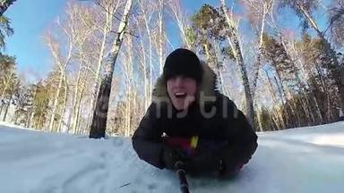 快乐的人骑着雪管在雪道上微笑。慢动作。 冬天的雪景。 户外运动