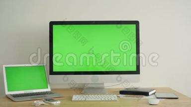 桌上有绿色屏幕的电脑显示器