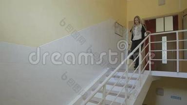 美丽的年轻女商人下班后幸福地走下楼梯