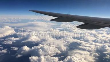 飞行在云层之上的飞机的机翼。 人们从飞机的窗口看天空，用空中<strong>交通工具</strong>