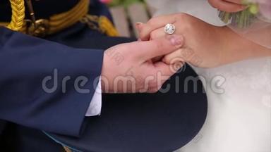 年轻的已婚夫妇牵着手，<strong>结婚典礼</strong>。 新郎把结婚戒指戴在新娘身上