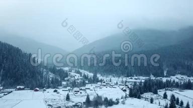冬季山区有人居住地区的空中活动。 雪山山坡上的村庄建筑和房屋