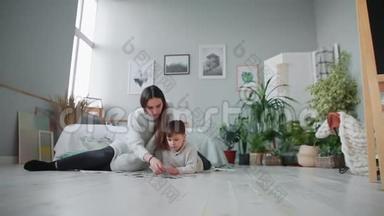 妈妈带着一个孩子在他家白色的内部和他的小儿子一起收集拼图。 快乐