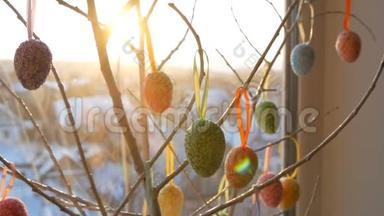 春天的日出突破了装饰树枝，上面挂着五颜六色的复活节彩蛋