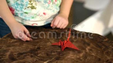 女人的手把<strong>纸鹤</strong>放在桌子上。