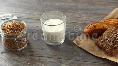 新鲜的自制面包，牛奶和小麦谷物在一个乡村木制桌子上。 自然健康的饮食..