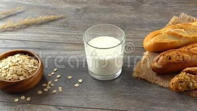 碗里的燕麦片，一杯牛奶和一张乡村木桌上的新鲜自制面包。