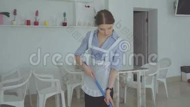 做梦的女仆在洗地板。 女孩在餐馆里打扫地板拖把
