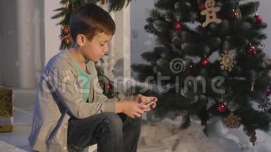 男孩在圣诞树附近<strong>玩手机</strong>、儿童和智能<strong>手机</strong>