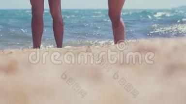 一对夫妇在海边的海滩上。 一对夫妇站在海滨，脚上沾满了水。 夏天和放松