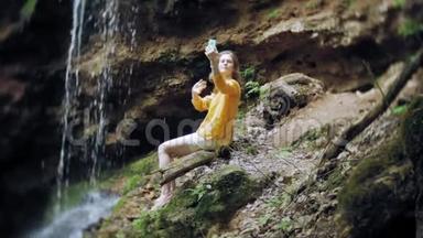 旅行冒险女在山上<strong>瀑布</strong>上<strong>拍摄</strong>智能手机，欣赏大自然的美丽景色