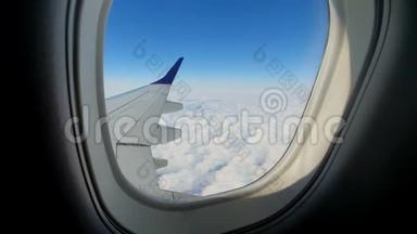 通过飞机的窗口查看.. 飞机的机翼顶着蓝天白云.. 背景