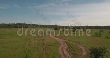 空中观景。 农村公路之间的农田和电力高压支架。 绿色田野之间的乡村道路。 4K