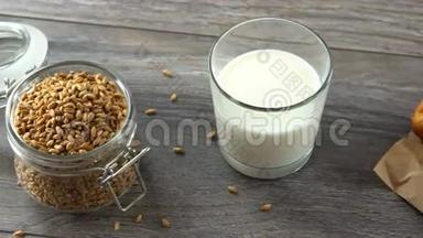 新鲜的自制面包、麦粒和牛奶放在乡村的木桌上。 自然健康的饮食..