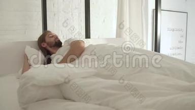 男人睡觉，早上醒来，躺在床上，穿着白色亚麻布