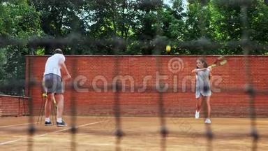 教练教年轻女孩打网球。