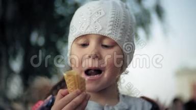 穿白色针织帽子的可爱学步女孩吃冰淇淋