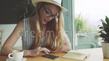 女孩在手<strong>机上</strong>和朋友聊天。 女人在咖啡馆的智能手<strong>机上</strong>写按摩，微笑。