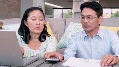 一对夫妇用笔记本电脑计算账单