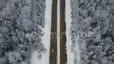 4K. 在冰冻的冬季森林里驾驶汽车飞越公路。 高空俯视图