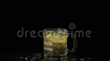 绿茶。 玻璃杯，有机干绿茶叶和柠檬片，漂浮在杯内热水。 慢动作。