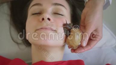 在水疗中心的年轻女子接受了一个与蜗牛Achatina的面部按摩。 蜗牛吃的是从生<strong>产出</strong>来的死皮。 在
