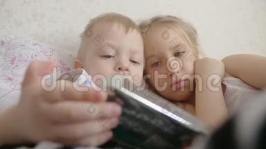 可爱的弟弟妹妹使用数字平板电脑，微笑着，看上去很<strong>开心</strong>。 兄弟姐妹玩得<strong>开心</strong>