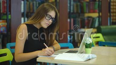 在<strong>城市图</strong>书馆的笔记本电脑上工作的严肃的女学生