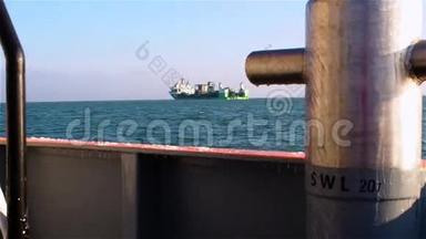 从拖轮甲板上看到远处的绿船，船上挂着锚