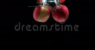 苹果，苹果，黑背景下进入水中的水果，