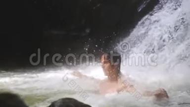在热带丛林的瀑布中，英俊的男人在溪水下放松。 慢动作。 1920x1080