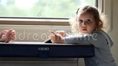 女孩在火车上玩智能手机游戏。 宝宝在马路上玩手机游戏..