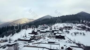 冬季山区有人居住地区的空中活动。 雪山山坡上的村庄建筑和房屋