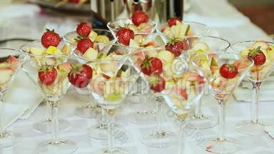 在一张白色桌子上放着草莓的玻璃杯里的<strong>水果</strong>。 庆祝<strong>活动</strong>。 特写镜头。