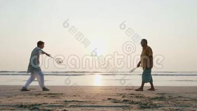 活跃的老夫妇在海滩上缓慢地打太极球。