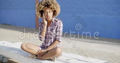 有智能手机的女人坐在石壁上