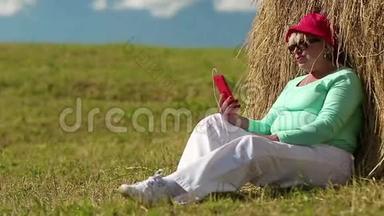 女人坐在绿草上，通过手机<strong>交流</strong>