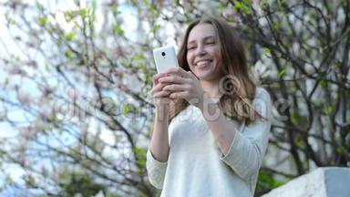 在智能手机上使用应用程序的女人微笑着在手机上发短信