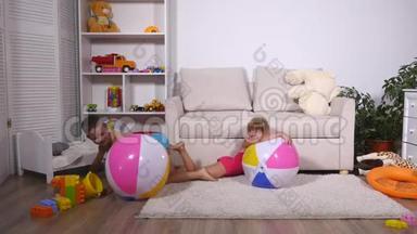 孩子们玩得很开心，<strong>坐</strong>在游戏室里的大橡胶充<strong>气球</strong>上