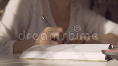女人每天写一支钢笔。 那个女人在笔记本上做<strong>条目</strong>。 女人在工作。 女人在里面做<strong>条目</strong>