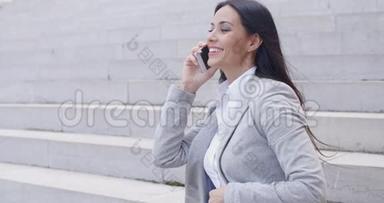 笑的女人坐在台阶上打电话