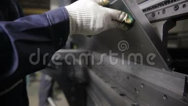<strong>无法识别</strong>的工人操作弯曲设备，弯曲金属片在一个工业工厂。